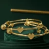 Twin Hearts Gold Bangles for Women with Crystal Detailing and Bell Charms
